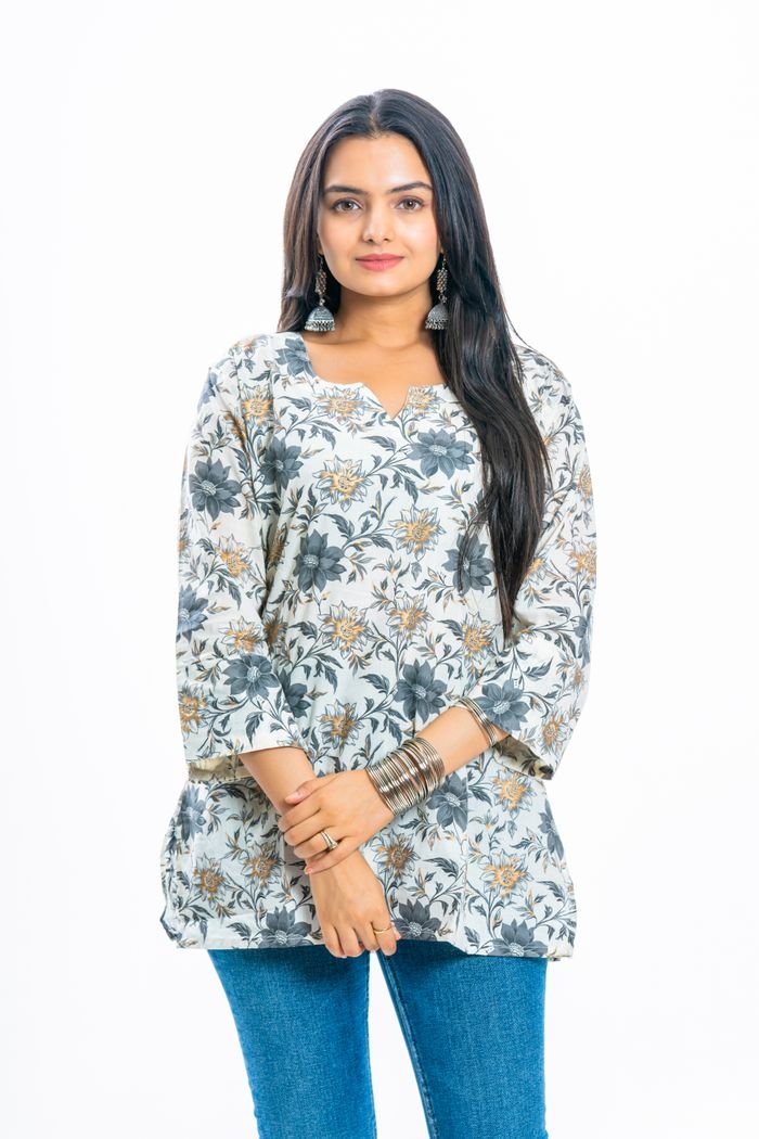 Chic woman in floral tunic and jeans, showcasing modern fashion.